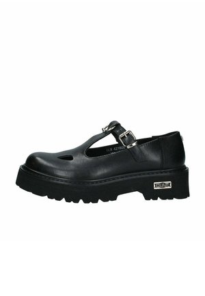 Scarpe Mary Jane in pelle nera con punta arrotondata, dettagli intagliati, fibbia regolabile e suola in gomma spessa con grip testurizzato.