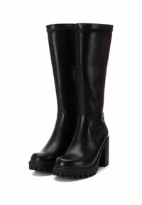 Botas altas de cuero negro con un tacón bloque ancho, cremallera lateral y suela resistente. Textura suave y diseño aerodinámico.