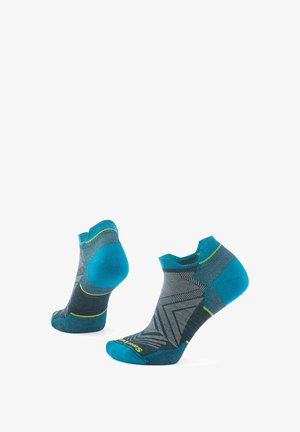Meias de comprimento até o tornozelo com um design azul e cinza, apresentando padrões geométricos, uma sola almofadada e detalhes amarelos nas bordas.