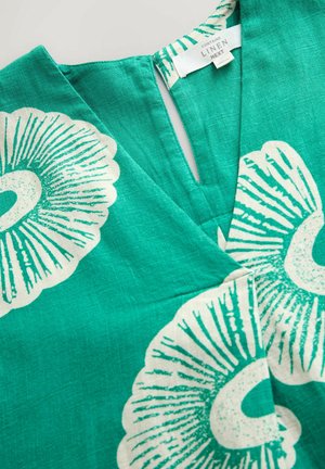 Turquoise linen fabric features large white floral patterns with detailed lines. V-neck design with a slight opening at the neckline.