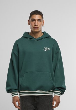 Sweat à capuche vert avec une poche kangourou, des poignets et un ourlet côtelés à rayures, et un logo blanc brodé sur la poitrine. Texture de tissu douce.