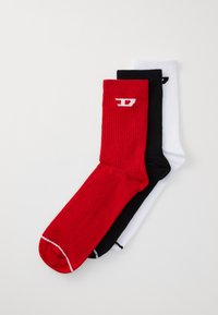 Une paire de chaussettes mi-mollet : rouges avec des accents blancs, noires et blanches. Texture côtelée avec un logo sur le côté supérieur, présentant des couleurs contrastées.