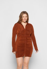 Vestido cor ferrugem com frente abotoada, mangas longas e detalhes franzidos nas laterais. Feito de um tecido texturizado.