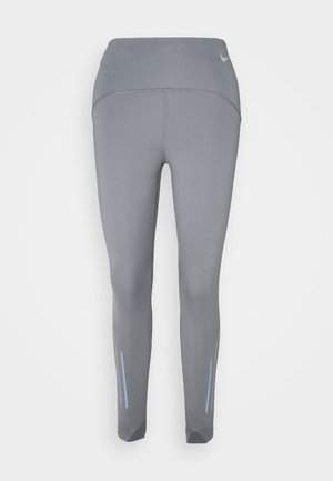 Szare legginsy sportowe wykonane z elastycznego materiału, z wysokim stanem, odblaskowymi akcentami oraz zwężanym krojem z bocznymi paskami.