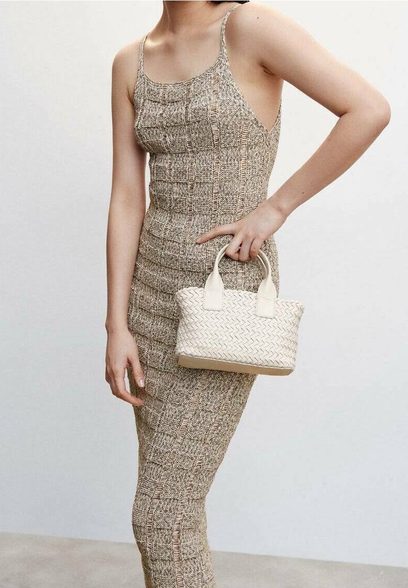 Robe beige tissée avec une silhouette ajustée et de fines bretelles, associée à un petit sac blanc tressé à deux poignées.