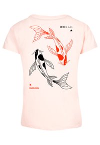 Pale pink t-shirt featuring two koi fish in red and black ink, with stylized fins and patterns, accompanied by Japanese text and a star design.