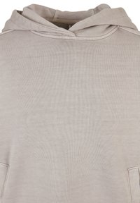 Felpa con cappuccio in morbido tessuto beige, con tasca a marsupio, un ampio cappuccio e dettagli a coste ai bordi per un effetto di texture.