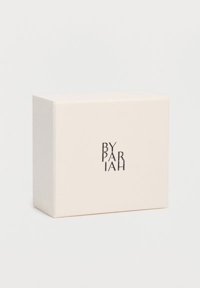 Κρεμ ορθογώνιο κουτί με υφή στην επιφάνεια και το όνομα της μάρκας "BY PARIAH" τυπωμένο με μαύρη γραμματοσειρά στο μπροστινό μέρος.