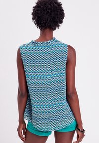 Ärmløs bluse med rund halsudskæring, prydet med et multicolor geometrisk mønster i blå, grøn og hvid. Letvægtigt stof, afslappet pasform.