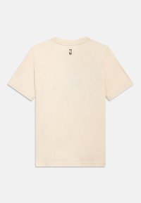 Krátké rukávy, krémově zbarvené tričko z bavlny. Má kulatý výstřih a malou značkovou štítek na zadní straně. Hladká textura.