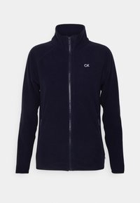 Marinblå fleecejacka med hög krage, dragkedja fram och sidofickor. Har CK-logotyp i vit sömnad på vänster bröst. Mjuk textur.