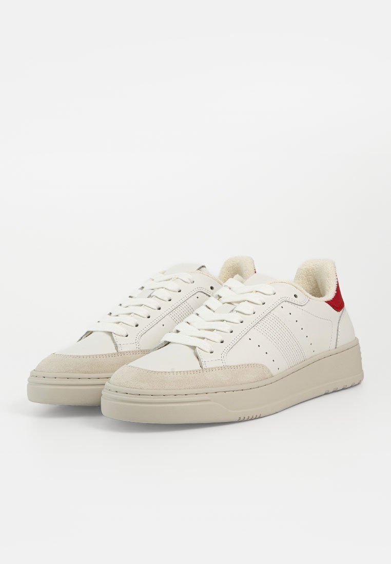 Weiße Ledersneaker mit beigen Wildlederelementen, ausgestattet mit roter Fersenschlaufe, durchbrochenen Details und einer strukturierten Gummisohle.