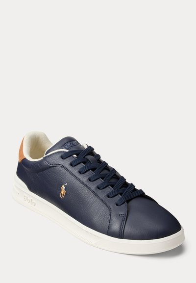 Αθλητικό παπούτσι από δέρμα σε ναυτικό μπλε με λευκή σόλα, μπλε κορδόνια, ταμπά τακούνι και μικρό κεντητό λογότυπο παίκτη πόλο στο πλάι.