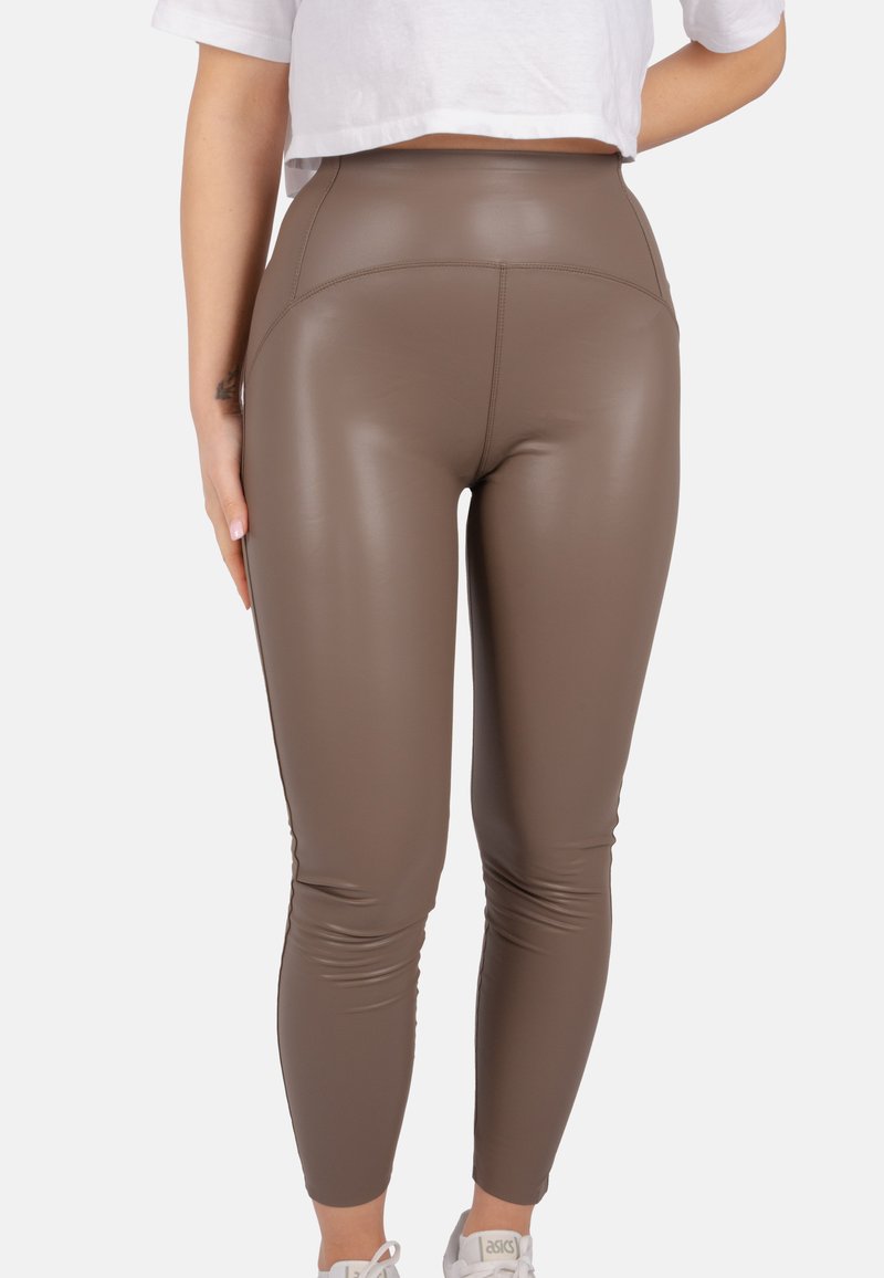 Leggings marron taille haute en matériau brillant, effet cuir, avec un design ajusté et une texture lisse, de longueur mi-mollet.