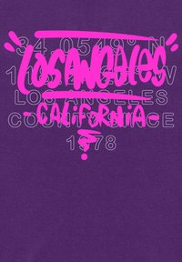 Fialové grafické tričko s jasně růžovým nápisem, které obsahuje "LOS ANGELES" a souřadnice, vedle "CALIFORNIA" a "1978."