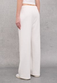 Witte, wijde sweatpants met een elastische tailleband, gemaakt van zachte, gestructureerde stof, met gestikte boorden en zijnaad.