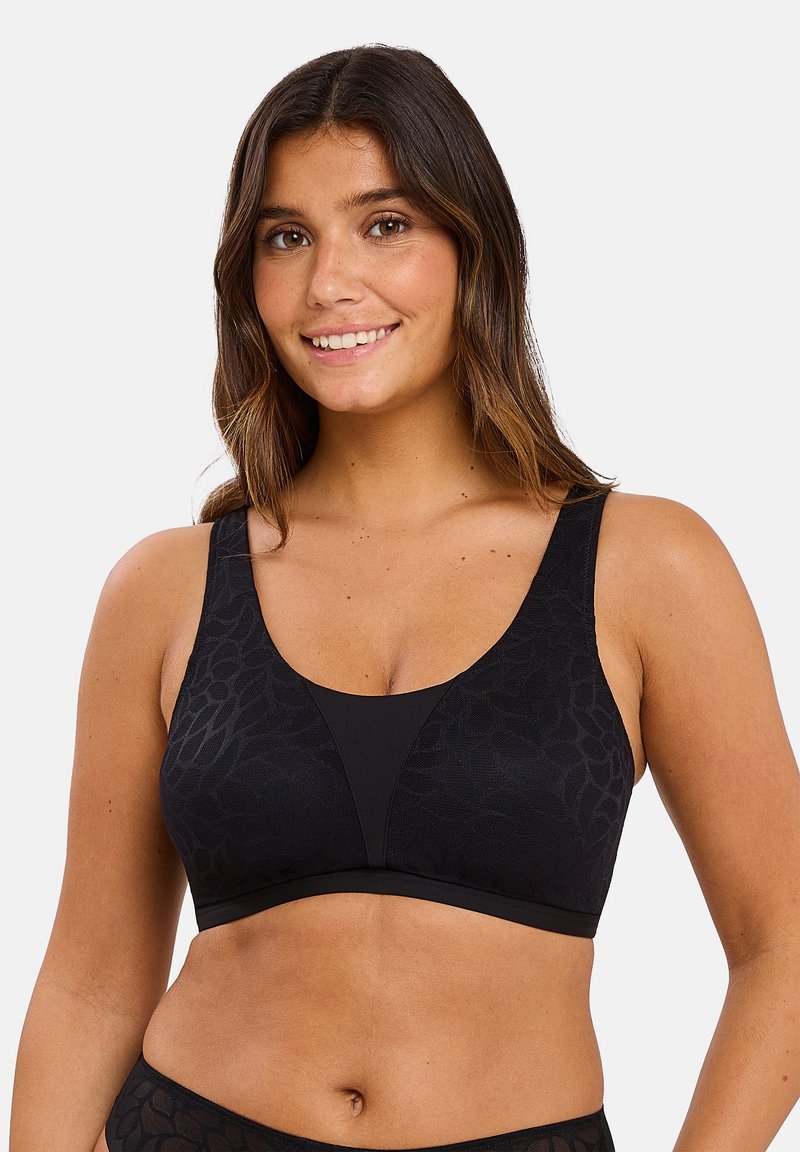 Bralette noir avec une texture lisse, de larges bretelles et un motif floral subtil. Le design comprend un décolleté en V profond et une finition sans couture.