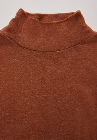 Maglione a collo alto marrone e elasticizzato con una texture liscia e un colletto a coste. Il tessuto presenta un sottile motivo melangiato.