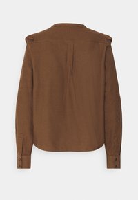 Brun rutigt skjorta med långa ärmar, knäppning vid ärmsluten och en veckad bakdesign för extra textur. Mjuk material med en avslappnad passform.