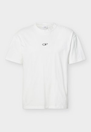 Hvit kortermet rund hals T-skjorte med en liten svart abstrakt logo sentrert på brystet, vist mot en nøytral bakgrunn.