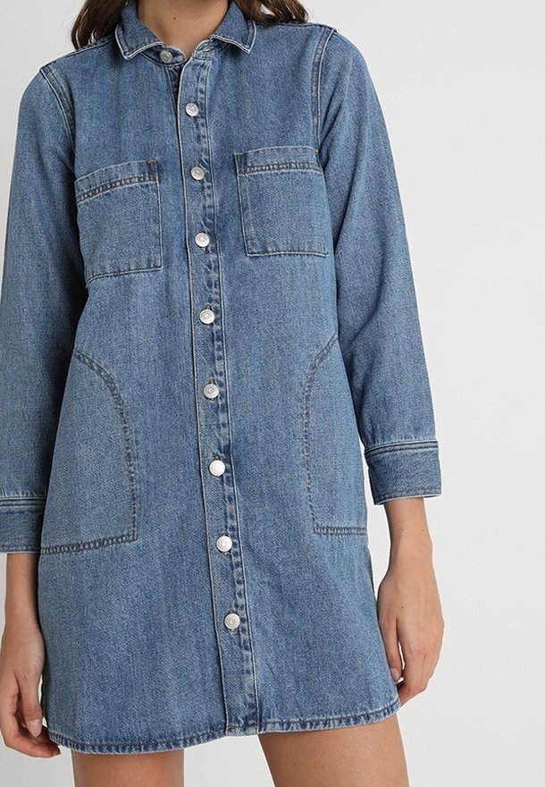 Denimskjortklänning i ljusblått med långa ärmar, knäppning fram, två bröstfickor och sidfickor. Har en avslappnad passform och rak nederkant.