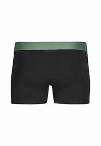 Schwarze Boxershorts mit einem grünen elastischen Bund; glatte Stoffstruktur; taillierte Passform mit einem kurzen Beinansatz.