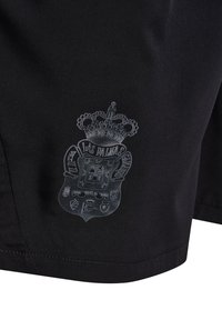 Tissu noir avec un blason détaillé imprimé comprenant une couronne, un bouclier et le texte « Las Palmas Gran Canaria » dans la partie inférieure.