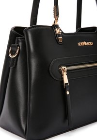 Borsa nera in pelle liscia, con dettagli in metallo dorato, una tasca frontale con zip e due manici superiori per il trasporto.