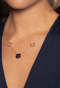 Rose gold necklace featuring a central round pendant and two floral accents on a delicate chain. Smooth texture with polished finish.