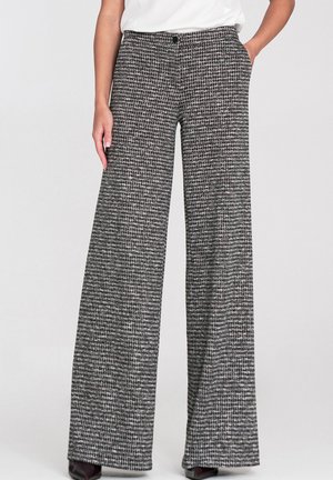 Spodnie o szerokich nogawkach w czarno-biały wzór pepitki. Wykonane z teksturowanej tkaniny, z zapięciem na guziki i kieszeniami bocznymi.