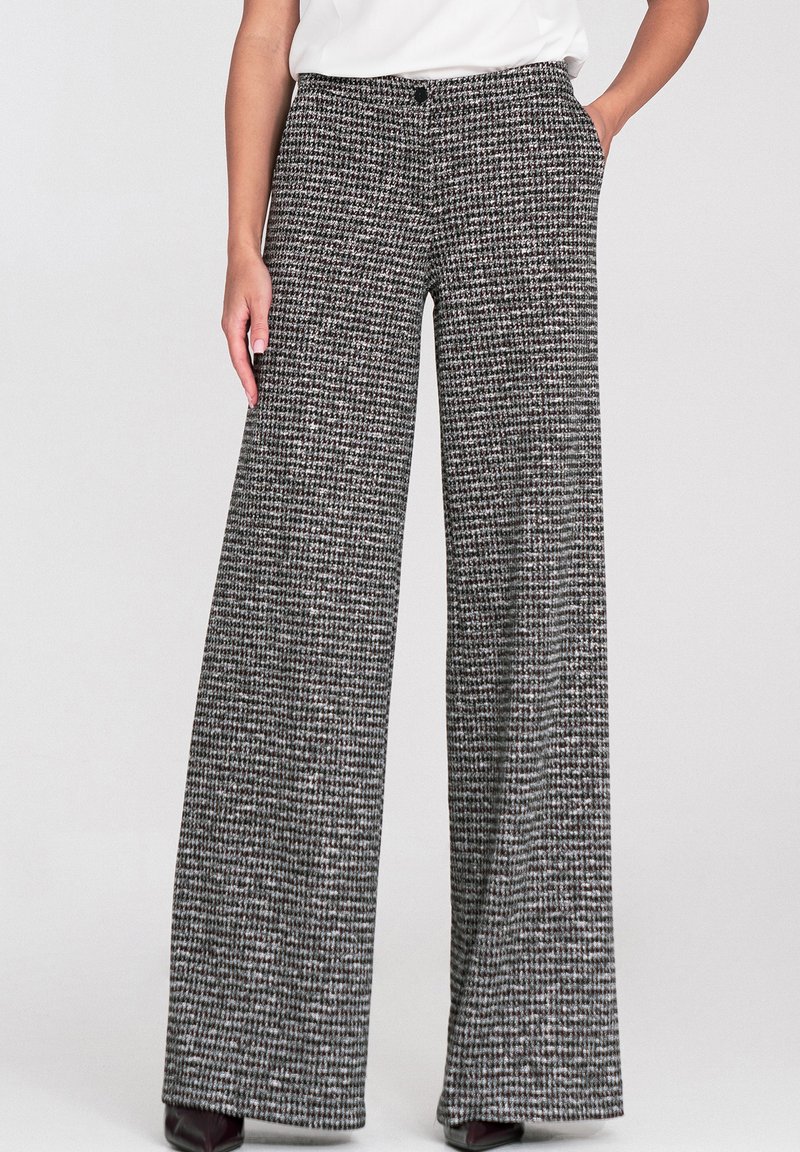 Spodnie o szerokich nogawkach w czarno-biały wzór pepitki. Wykonane z teksturowanej tkaniny, z zapięciem na guziki i kieszeniami bocznymi.