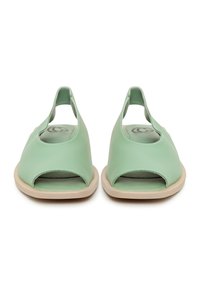Paire de chaussures plates slingback vert clair à bout ouvert avec semelles beiges, vues de face sur fond blanc.
