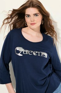 Chemise à manches longues bleu marine en tissu doux, avec un texte "Queens" imprimé en argent dans une police stylisée sur le devant.