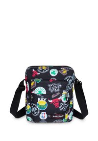 Bolso mensajero negro con estampados coloridos de logotipos deportivos. Cuenta con cierre superior con cremallera, correa ajustable y bolsillo frontal con parche de logotipo.