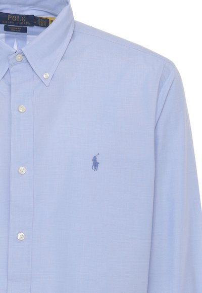 Camicia Polo Ralph Lauren azzurro chiaro con bottoni, colletto con bottoni e piccolo logo ricamato di un giocatore di polo sul petto.