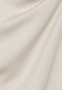 Hellbeige Stoff mit glatter Textur und subtiler Ausstrahlung. Verfügt über ein feines Rippenmuster und fällt elegant mit sanften Falten.