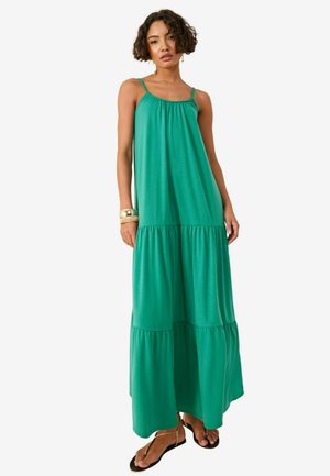 Robe maxi verte sans manches en tissu doux, avec un corsage froncé et une jupe à volants. Design long et fluide avec une coupe décontractée.