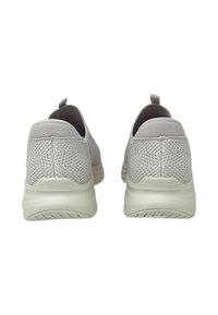 Un paio di sneakers slip-on in maglia grigia chiara con suole bianche imbottite, viste da dietro su uno sfondo bianco.