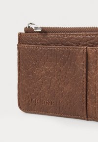 Brown leather wallet features a textured finish, zip closure, and embossed "Pier One" logo. Includes two card slots for convenient storage.