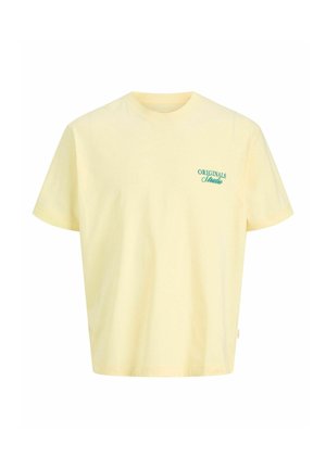 Halvány sárga rövid ujjú póló kerek nyakkivágással és zöld "ORIGINALS Studio" felirattal a bal mellrészen.