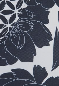 Tumesinine kangas, mis on kaunistatud suurte valgete lillemustriga, millel on peen detail ja ribakujuline tekstuur. Kujunduses on lehed ja detailsed kroonlehed.