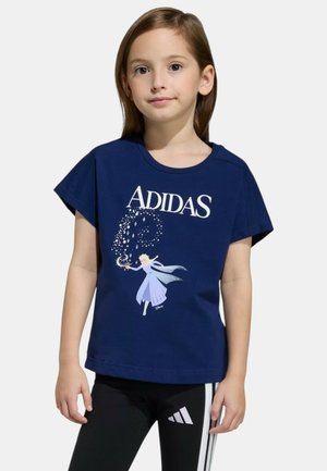 Ragazza giovane che indossa una maglietta Adidas blu navy con una grafica di Elsa della Disney e leggings Adidas neri con strisce bianche.