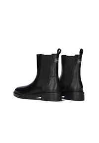 Pair of black leather ankle boots with textured sides, elastic panels, pull tabs, and low stacked heels on a white background.
