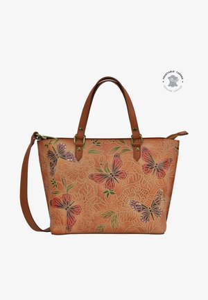 Tan leren handtas met vlinder- en bloemenpatronen, voorzien van bruine handvatten en een verstelbare strap. Accenten in zilverkleurig metaal.