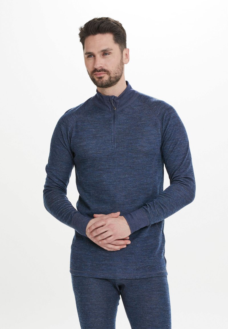 Mörkblå långärmad topp med kvartslång dragkedja i texturerat tyg, med en upphöjd krage, figurnära ärmar och diskreta stygnsdetaljer.