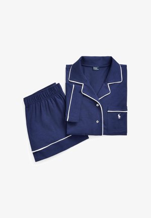 Donkerblauw pyjama-set van zachte stof, met witte bies, een knoopshirt met een zak en korte broek met een elastische tailleband.