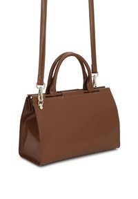 Καφέ ορθογώνια δερμάτινη τσάντα χειρός με κορυφαίες λαβές και αποσπώμενο ιμάντα ώμου, κρεμασμένη σε λευκό φόντο.