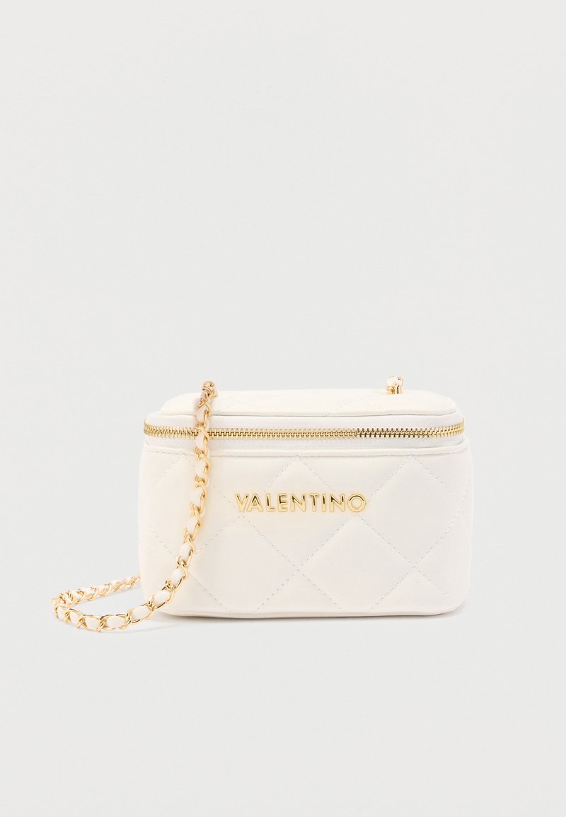 Μικρό λευκό καπιτονέ τσαντάκι Valentino χιαστί με χρυσή αλυσίδα και φερμουάρ σε απλό φόντο.