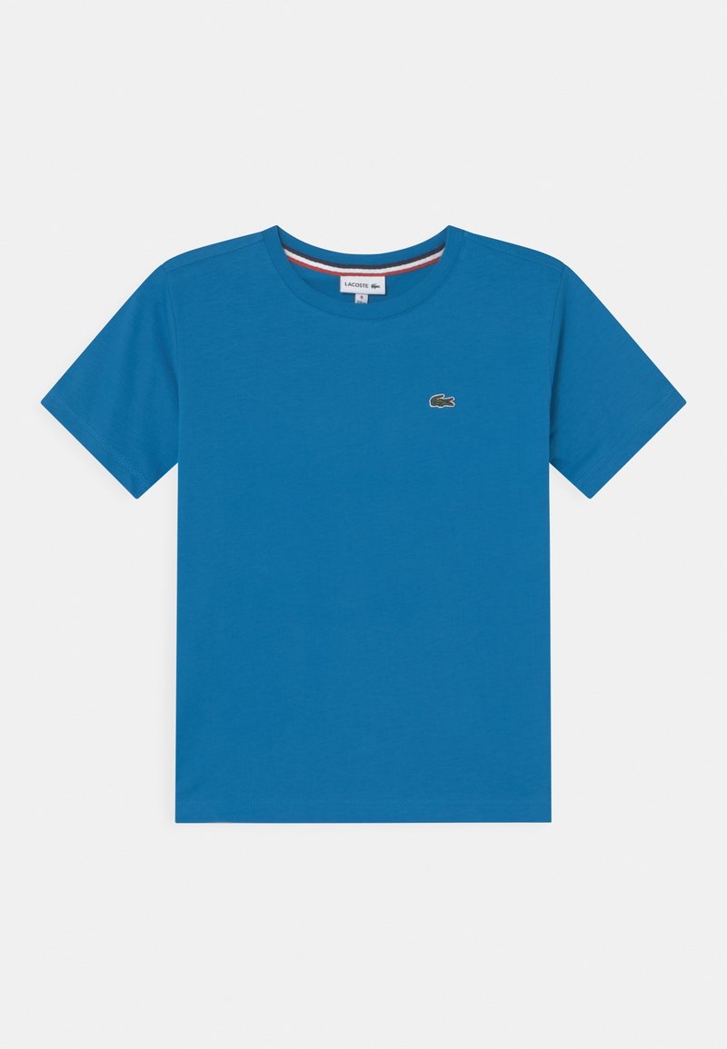 Sininen puuvillapaita lyhyillä hihoilla, pyöreällä kaula-aukolla ja pienellä vihreällä Lacoste-logolla vasemmalla puolella rintaa.