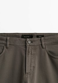 Pantalon gris texturé coupe slim avec fermeture boutonnée, passants pour ceinture, poches avant et étiquette de la marque Massimo Dutti à l'intérieur de la ceinture.